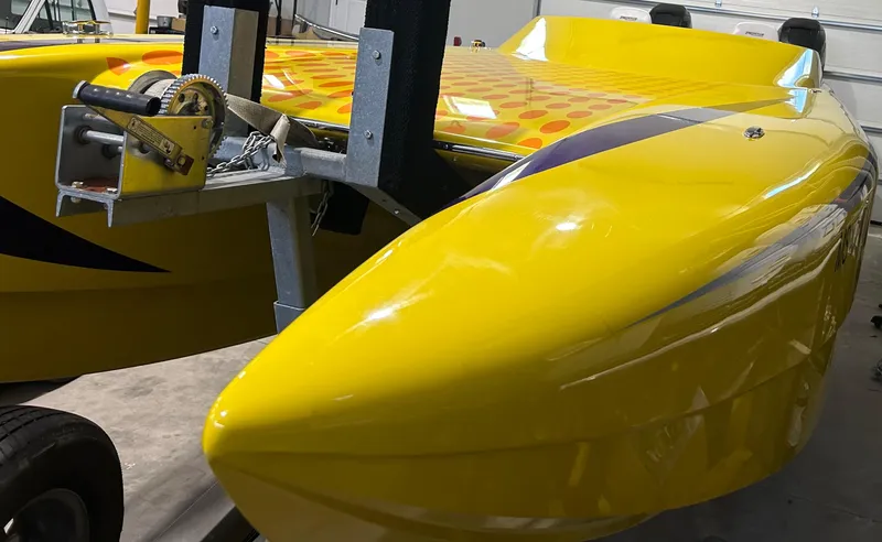 Slide: The Image of Yellow 2018 Predator C30 boat with vibrant design on trailer in garage. - 3