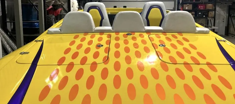 Slide: The Image of 2018 Predator C30 boat with vibrant yellow and orange polka dot design, white seats. - 8