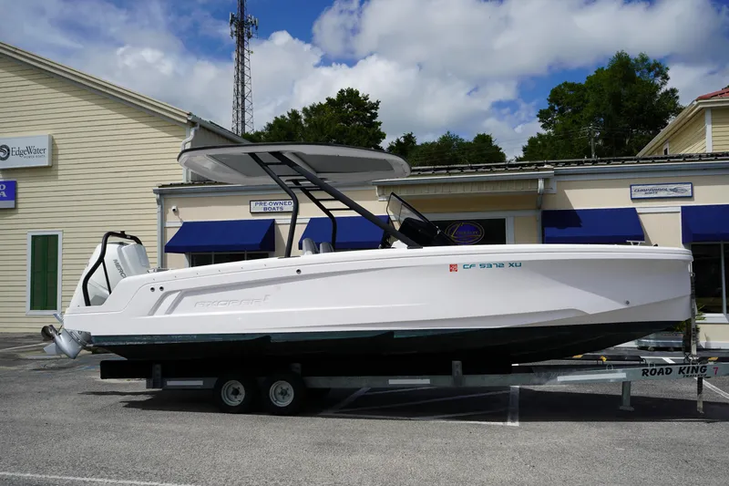 The Image of 2022 Axopar 22 T-Top boat on trailer, parked outside a dealership. - 0