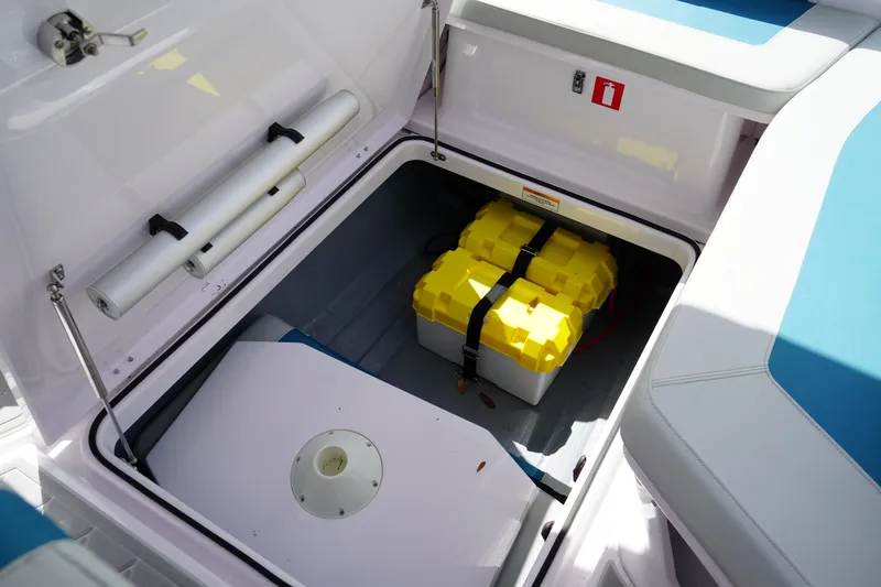 Slide: The Image of Open storage compartment in 2022 Axopar 22 T-Top boat with yellow battery box. - 12