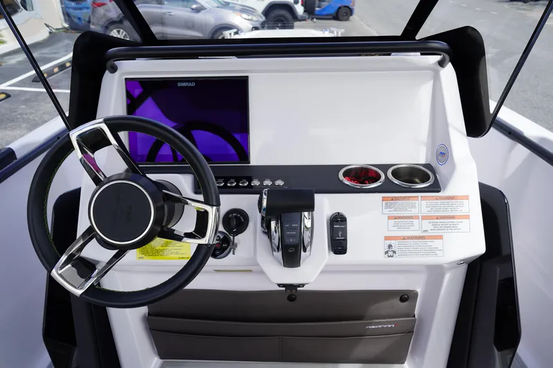 Slide: The Image of 2022 Axopar 22 T-Top boat dashboard with steering wheel and control panel. - 15