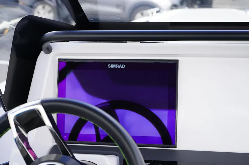 Slide: The Image of 2022 Axopar 22 T-Top dashboard featuring a Simrad display and steering wheel. - 18