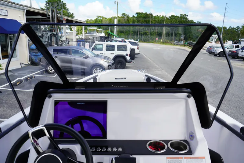 Slide: The Image of 2022 Axopar 22 T-Top boat dashboard with steering wheel and navigation display. - 19