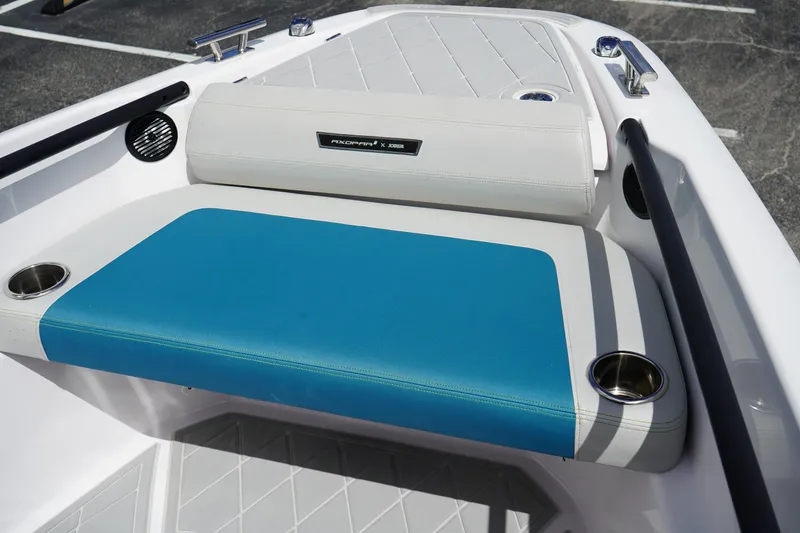 Slide: The Image of 2022 Axopar 22 T-Top boat seating with blue and white upholstery, featuring cup holders. - 26