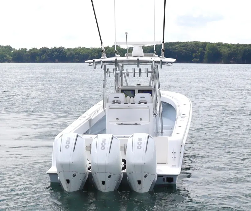 Slide: The Image of 2022 Contender 35 ST boat with triple outboard engines on a calm lake. - 3