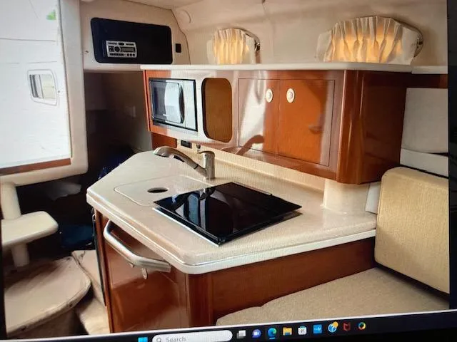 Slide: The Image of 2008 Sea Ray 260 Sundancer cabin kitchen with microwave, sink, and stove. - 12