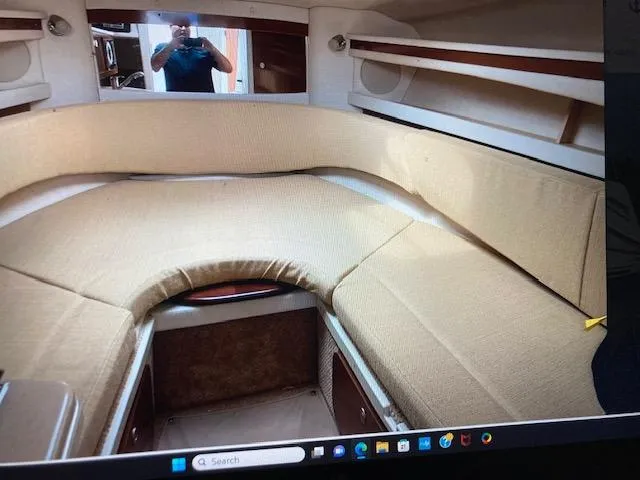 Slide: The Image of 2008 Sea Ray 260 Sundancer cabin interior with beige seating and wood accents. - 15