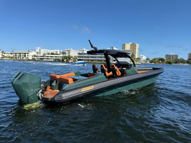 Slide: The Image of 2025 Skipper-BSK 38 boat on water, cityscape background, clear blue sky. - 6