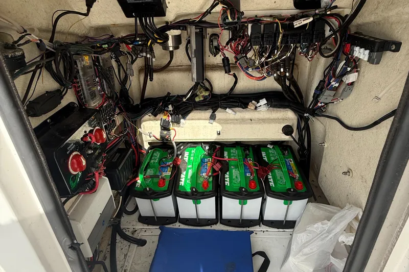 Slide: The Image of Electrical compartment of a 2018 BlackJack 256 boat with batteries and wiring. - 16