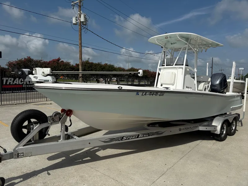 Slide: The Image of 2018 BlackJack 256 boat on trailer, parked outdoors under clear sky. - 4