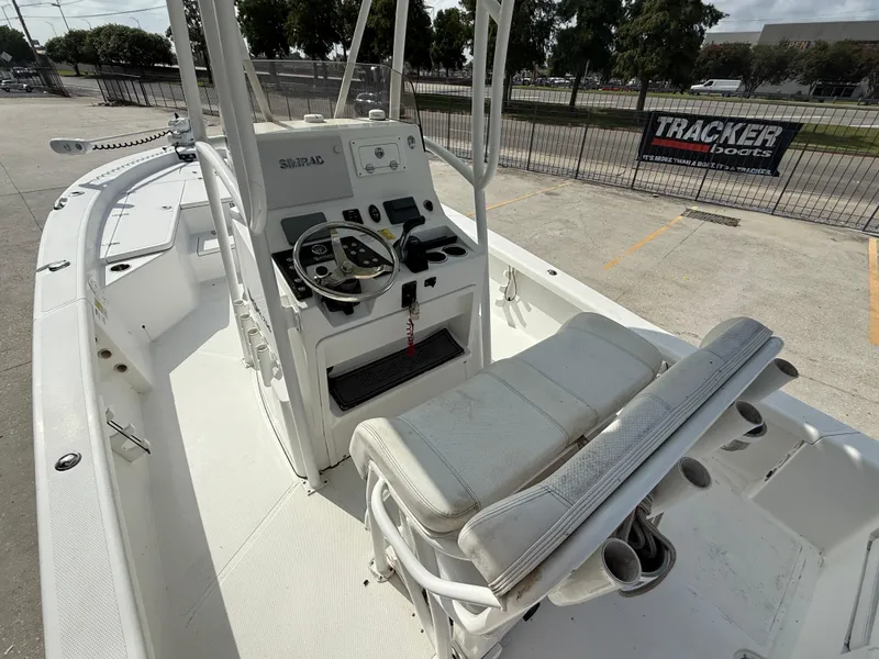 Slide: The Image of 2018 BlackJack 256 boat interior with steering console and seating, parked outdoors. - 9