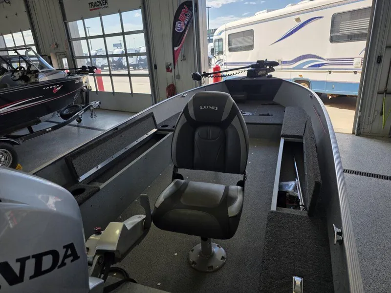 Slide: The Image of 2020 Lund 1600 Fury Tiller boat interior with Honda motor in showroom. - 7