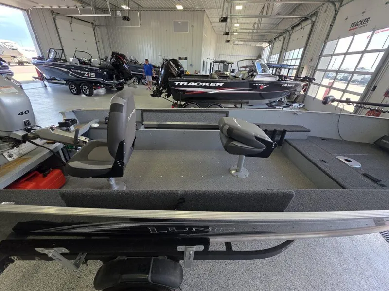 Slide: The Image of 2020 Lund 1600 Fury Tiller boat in showroom, featuring seating and motor. - 8