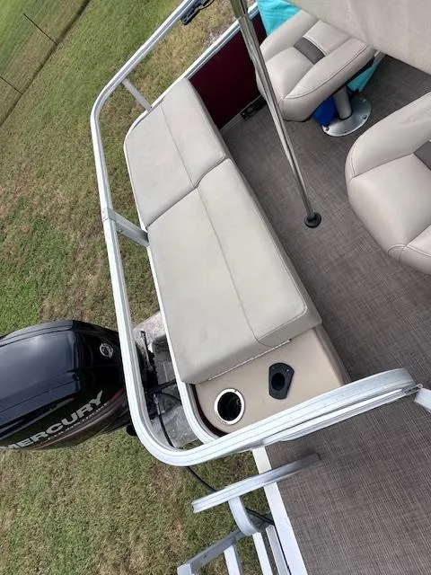 Slide: The Image of 2019 Sun Tracker SportFish 22 DLX pontoon boat interior with seating and Mercury outboard motor. - 10