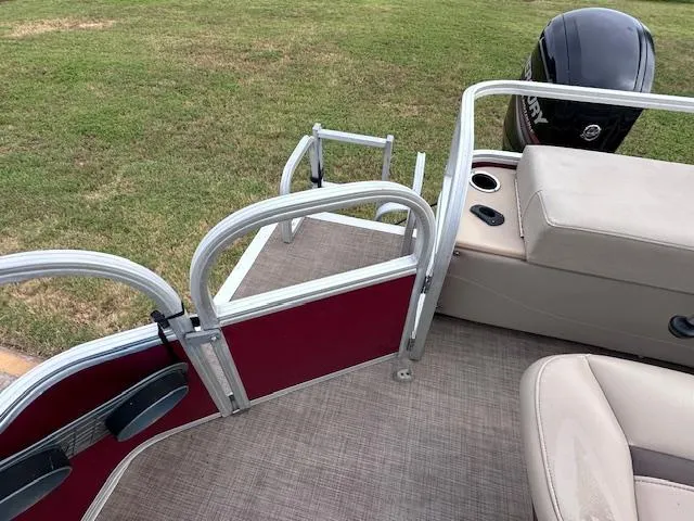 Slide: The Image of 2019 Sun Tracker SportFish 22 DLX pontoon boat interior with seating and motor view. - 11