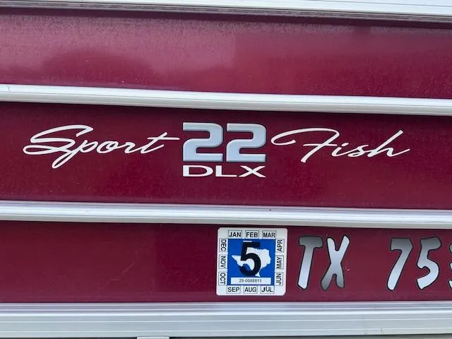 Slide: The Image of 2019 Sun Tracker SportFish 22 DLX boat with registration sticker, maroon exterior. - 15