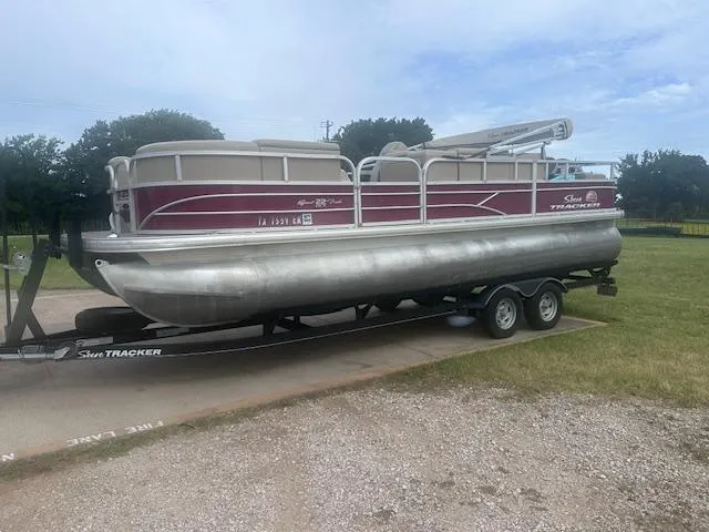 Slide: The Image of 2019 Sun Tracker SportFish 22 DLX pontoon boat on trailer, parked outdoors. - 18