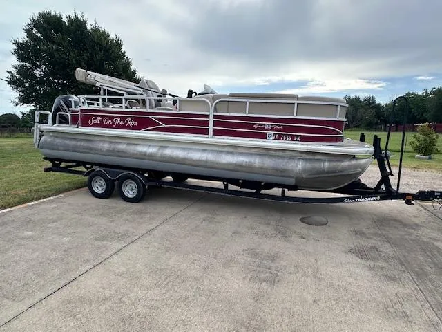 Slide: The Image of 2019 Sun Tracker SportFish 22 DLX pontoon boat on trailer, parked outdoors. - 3