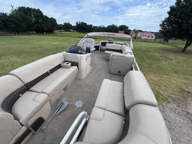 Slide: The Image of 2019 Sun Tracker SportFish 22 DLX pontoon boat with spacious seating on grassy area. - 6