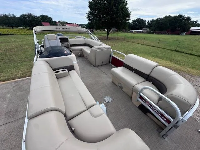 Slide: The Image of 2019 Sun Tracker SportFish 22 DLX pontoon boat with spacious seating, parked outdoors. - 7