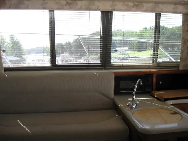 Slide: The Image of Interior of 1996 Carver 320 Voyager yacht with sofa, sink, and large windows. - 10