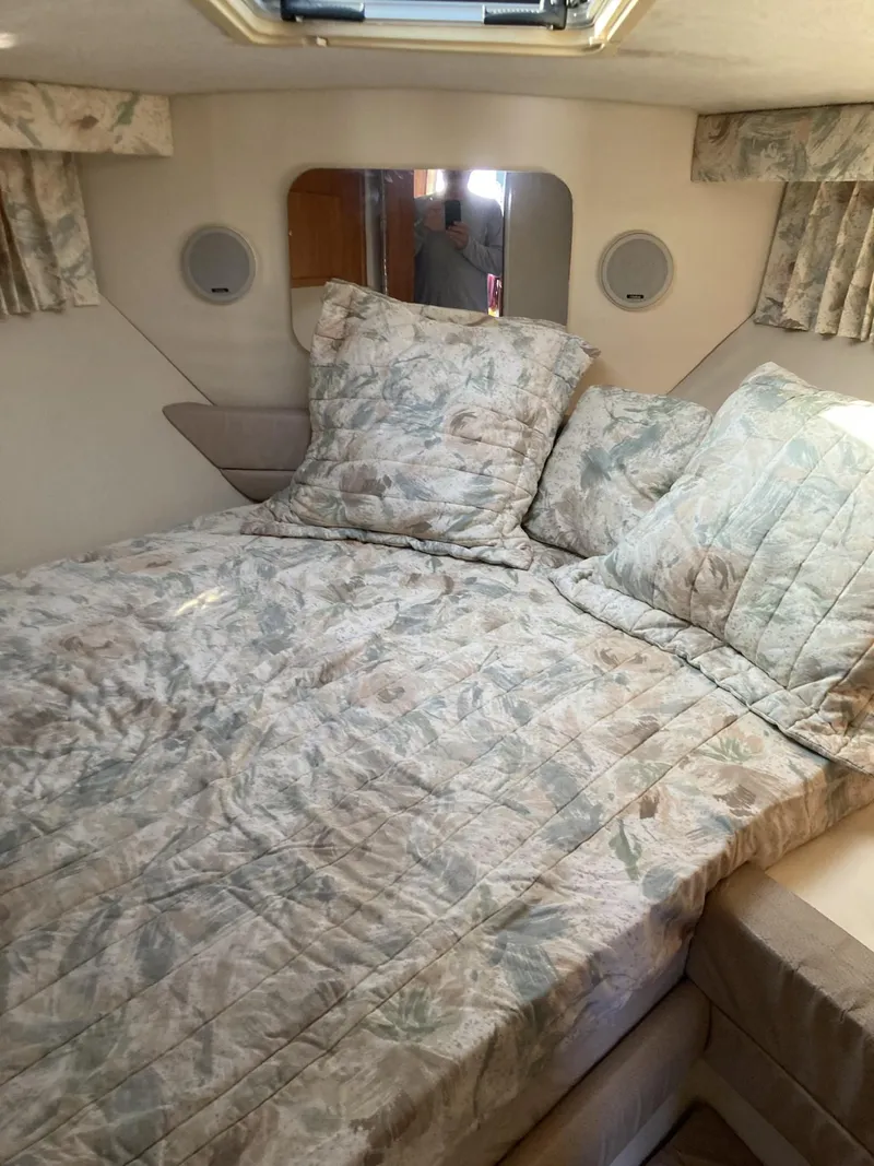 Slide: The Image of Cozy cabin interior of 1996 Carver 320 Voyager with floral bedding and soft lighting. - 11