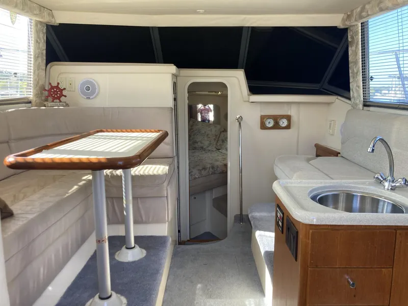 Slide: The Image of Interior of 1996 Carver 320 Voyager yacht with seating, table, and kitchenette. - 14