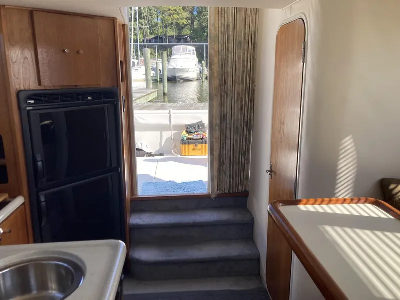 Slide: The Image of Interior of 1996 Carver 320 Voyager yacht with kitchenette and view of marina. - 16