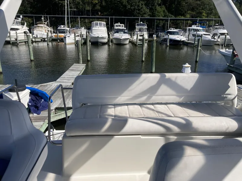 Slide: The Image of 1996 Carver 320 Voyager at marina, featuring spacious seating and docked boats in background. - 23