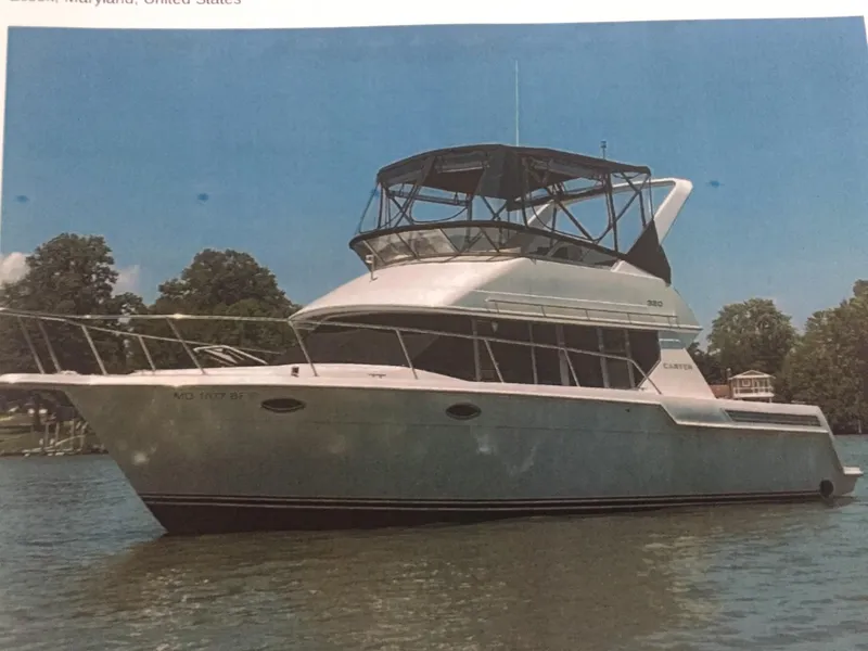 Slide: The Image of 1996 Carver 320 Voyager yacht on calm water, surrounded by trees. - 3