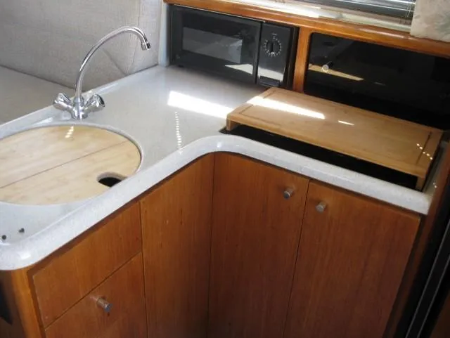 Slide: The Image of 1996 Carver 320 Voyager kitchen with wooden cabinets, sink, and microwave. - 8