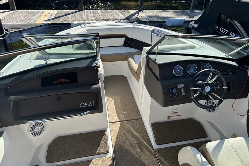 Slide: The Image of 2018 Cobalt CS23 boat interior with steering wheel and dashboard, docked at marina. - 10