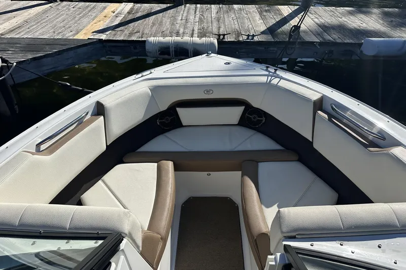 Slide: The Image of 2018 Cobalt CS23 boat interior with cushioned seating at dock. - 13