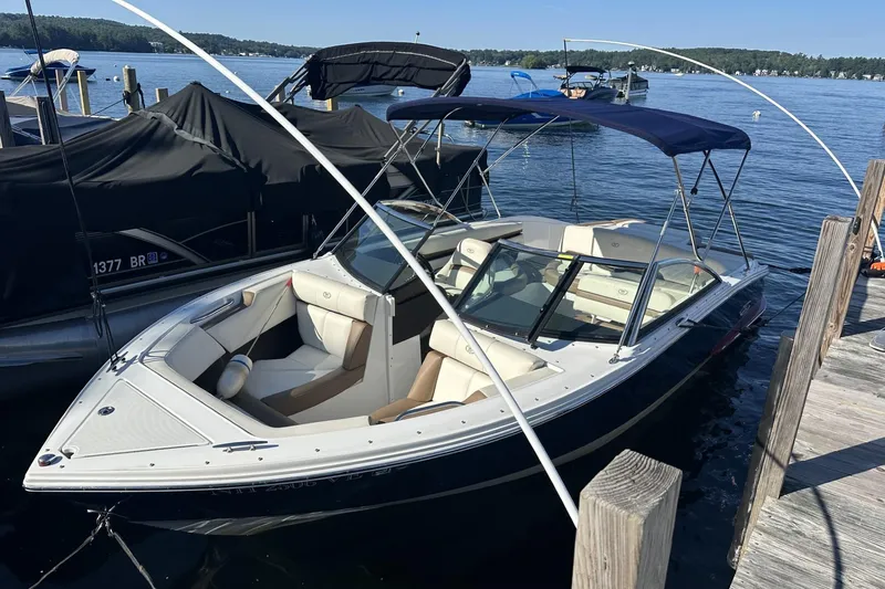 Slide: The Image of 2018 Cobalt CS23 boat docked on a serene lake with blue canopy. - 4