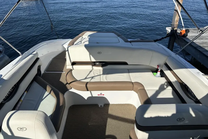 Slide: The Image of 2018 Cobalt CS23 boat interior with beige seating, docked by the water. - 6