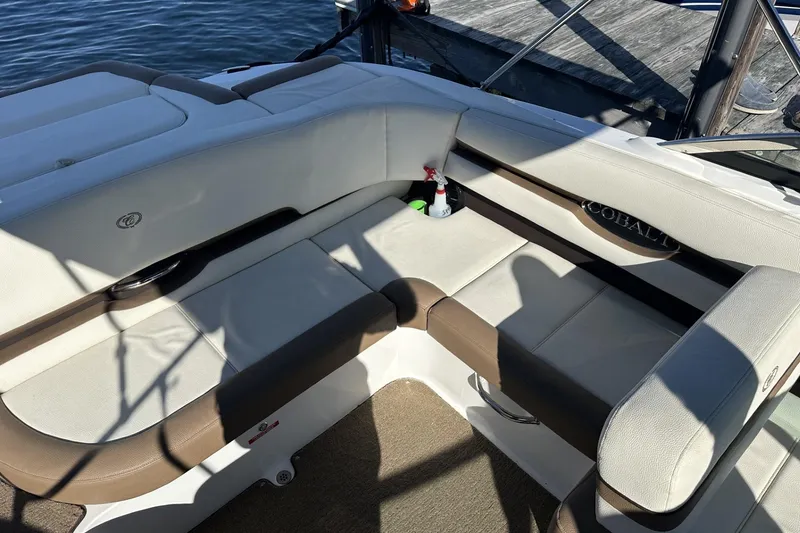 Slide: The Image of Luxurious seating on a 2018 Cobalt CS23 boat, docked by the water. - 9