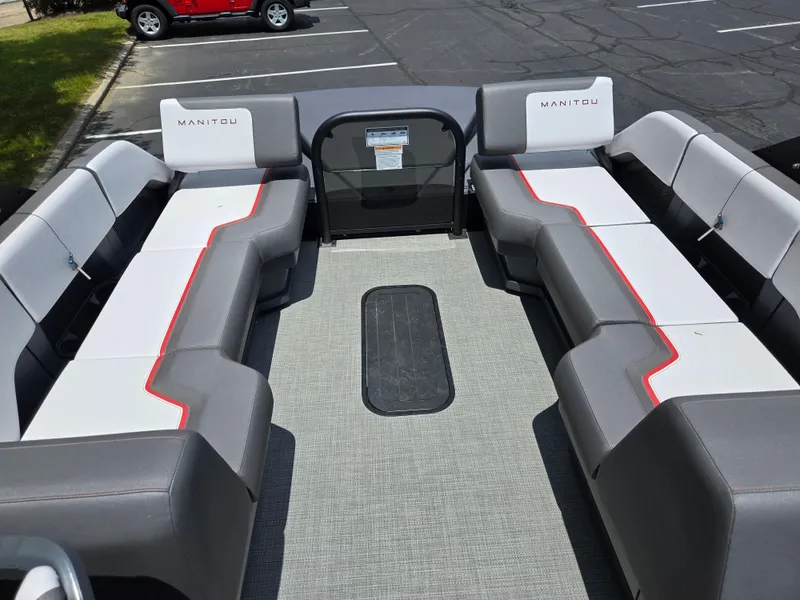 Slide: The Image of 2024 Manitou Cruise boat interior with gray and white seating, red accents, and spacious layout. - 12