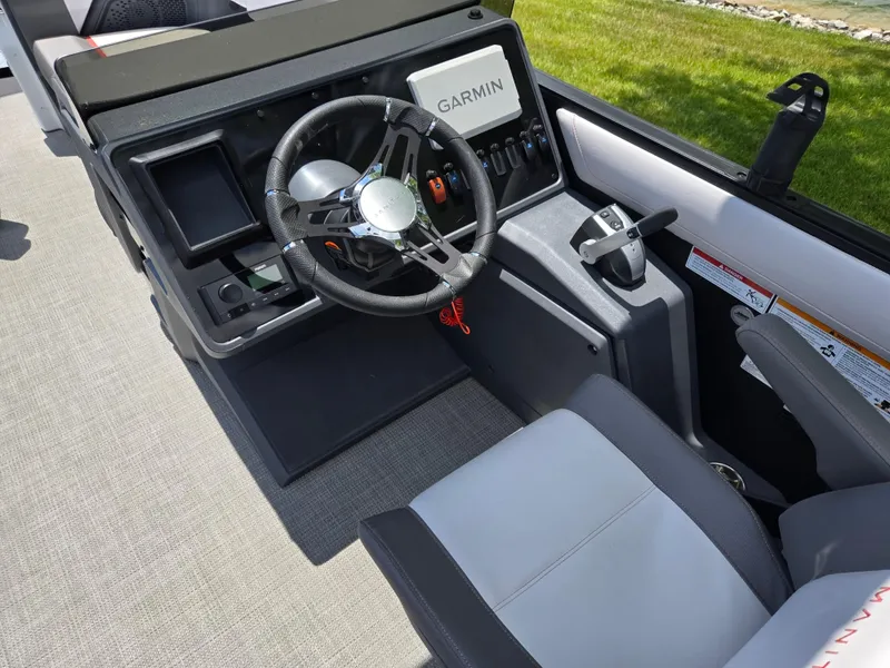 Slide: The Image of 2024 Manitou Cruise boat dashboard with Garmin navigation and modern steering wheel. - 16