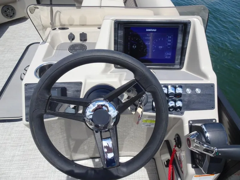 Slide: The Image of 2023 Harris Sunliner 250 boat dashboard with steering wheel and navigation display. - 15