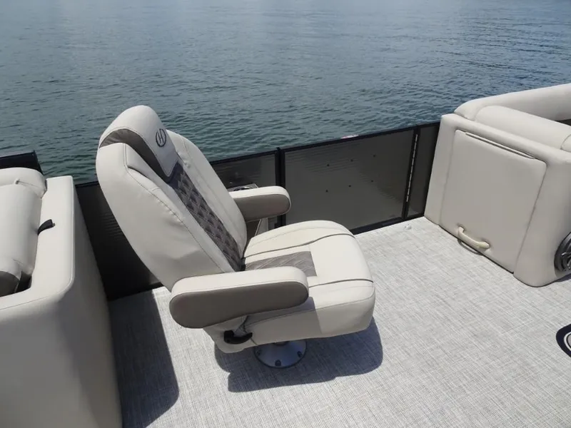 Slide: The Image of 2023 Harris Sunliner 250 boat interior with comfortable seating on calm water. - 18
