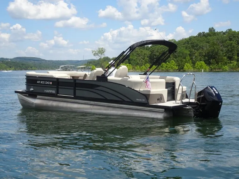 Slide: The Image of 2023 Harris Sunliner 250 pontoon boat on a lake under a blue sky. - 5