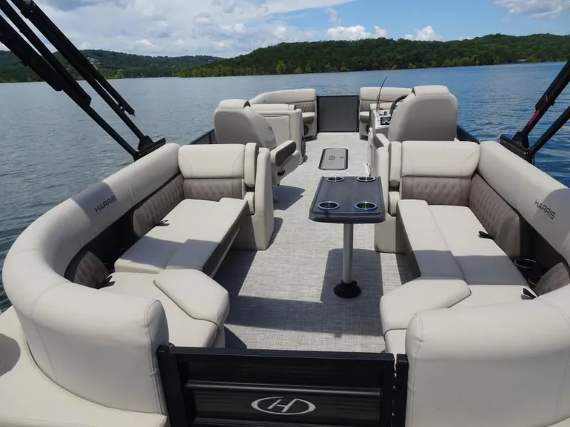 Slide: The Image of 2023 Harris Sunliner 250 pontoon boat with spacious seating on a scenic lake. - 8