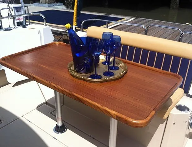 Slide: The Image of Elegant wooden table on 2014 Ranger Tugs R-31CB with blue glasses and bottle. - 14