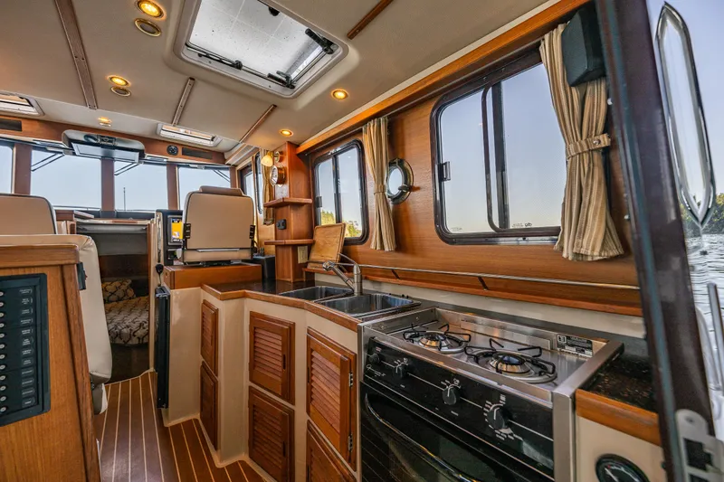 Slide: The Image of Interior of 2014 Ranger Tugs R-31CB boat with kitchen and seating area. - 17
