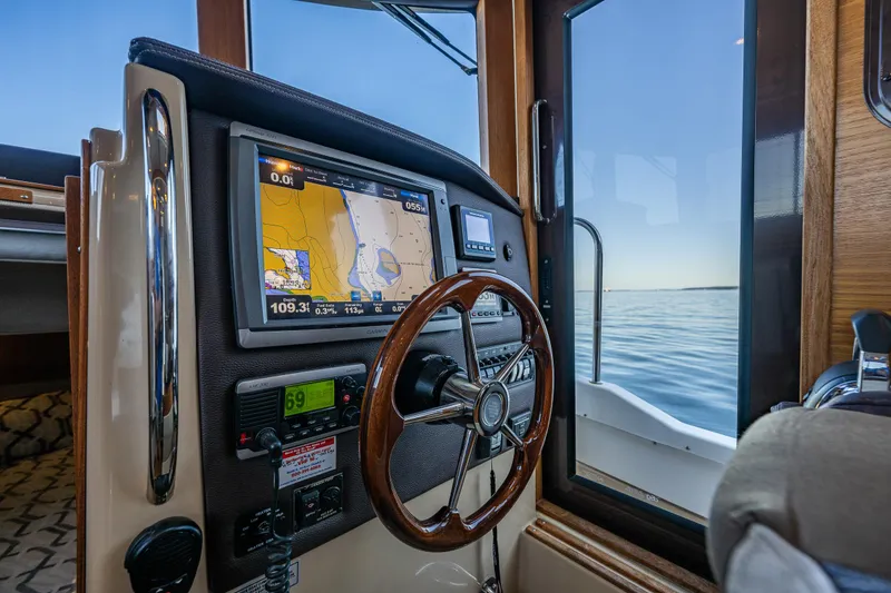 Slide: The Image of 2014 Ranger Tugs R-31CB helm with navigation display and wooden steering wheel. - 20
