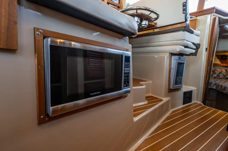Slide: The Image of 2014 Ranger Tugs R-31CB interior with microwave and wooden steps. - 22