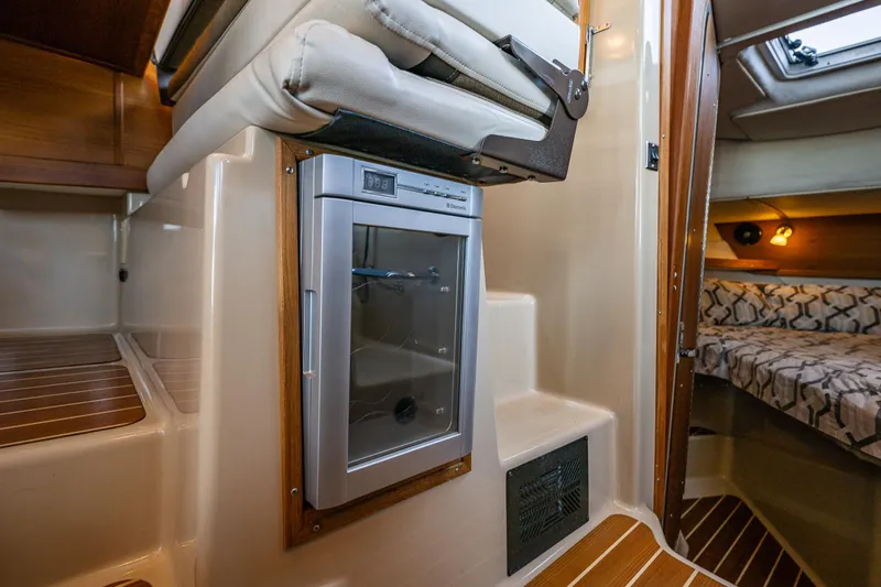 Slide: The Image of 2014 Ranger Tugs R-31CB interior with compact fridge and cozy cabin space. - 23