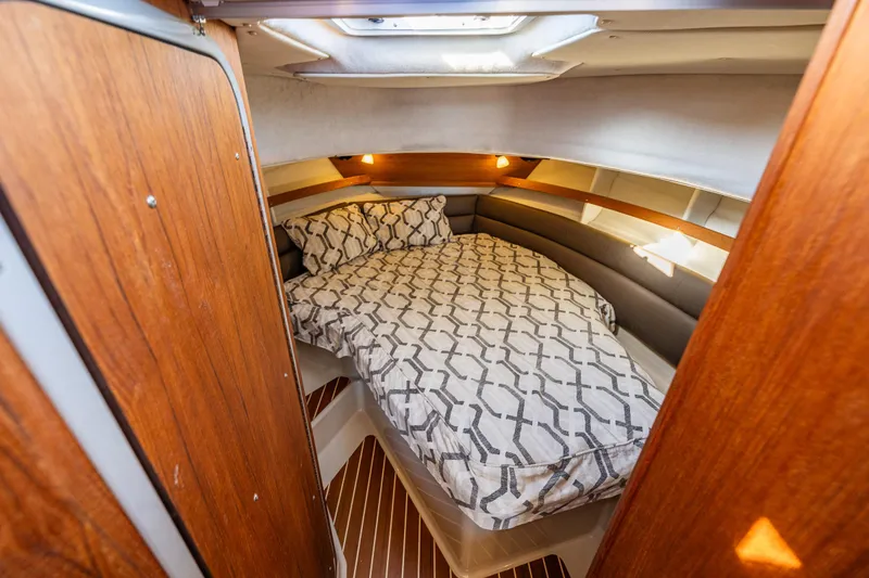 Slide: The Image of Cozy cabin interior of 2014 Ranger Tugs R-31CB with patterned bedding and wood accents. - 28