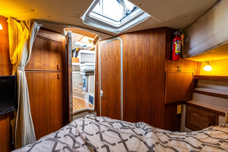 Slide: The Image of Cozy interior of 2014 Ranger Tugs R-31CB boat with wood paneling and bedding. - 30