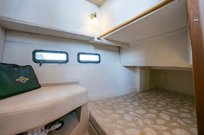 Slide: The Image of 2014 Ranger Tugs R-31CB cabin interior with cozy bed and porthole windows. - 32